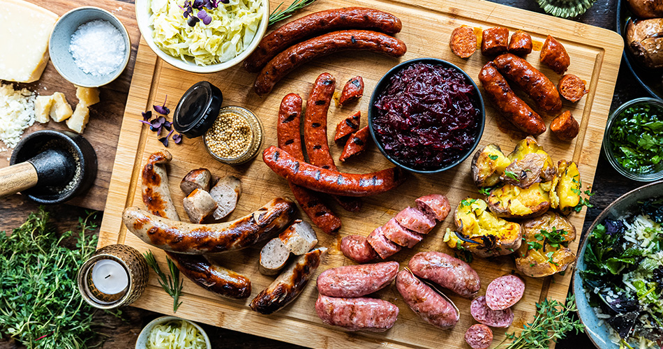 Diverse Wurstsorten auf einem Holztablett angerichtet. Salsiccia, Bratwurst und vieles mehr