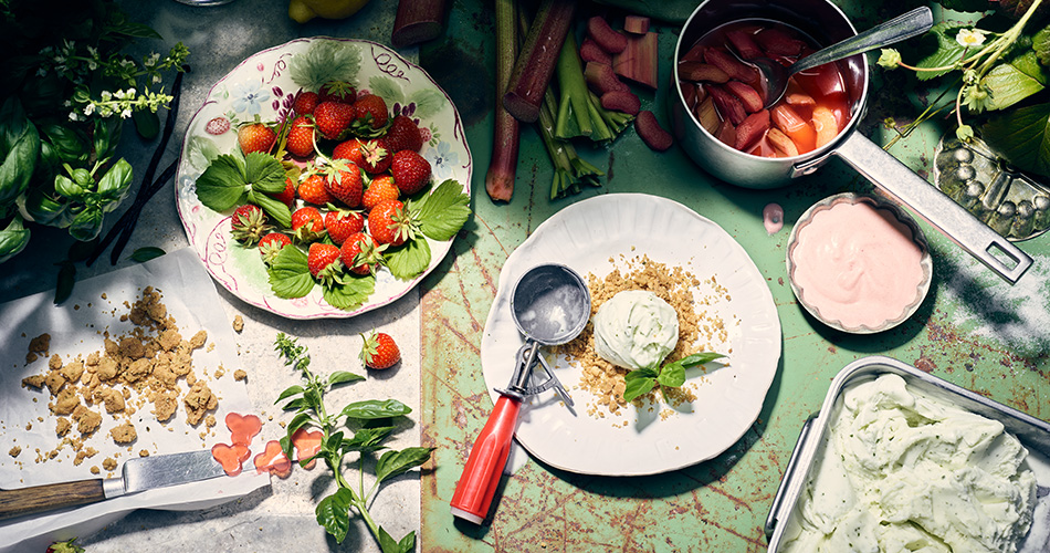 Sommerlich angerichtetes Eis aus Minze und mit Erdbeeren dekorierter Tisch