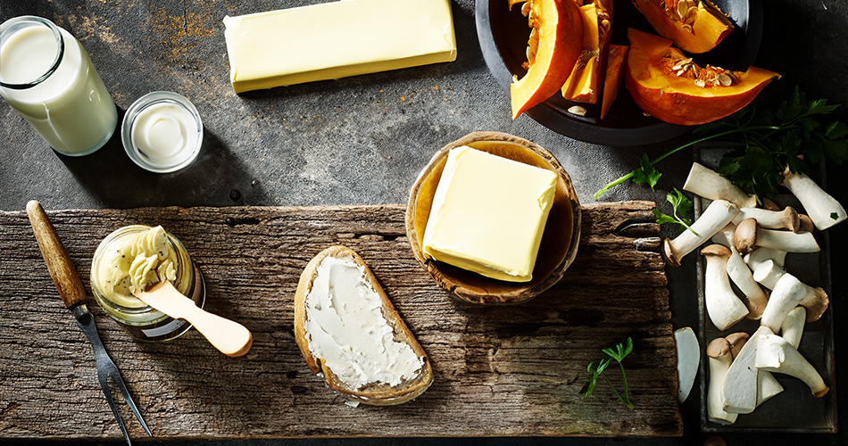 Butter Kategorie Verschiedene Buttersorten auf einem Holzbrett. Rustikale Optik.